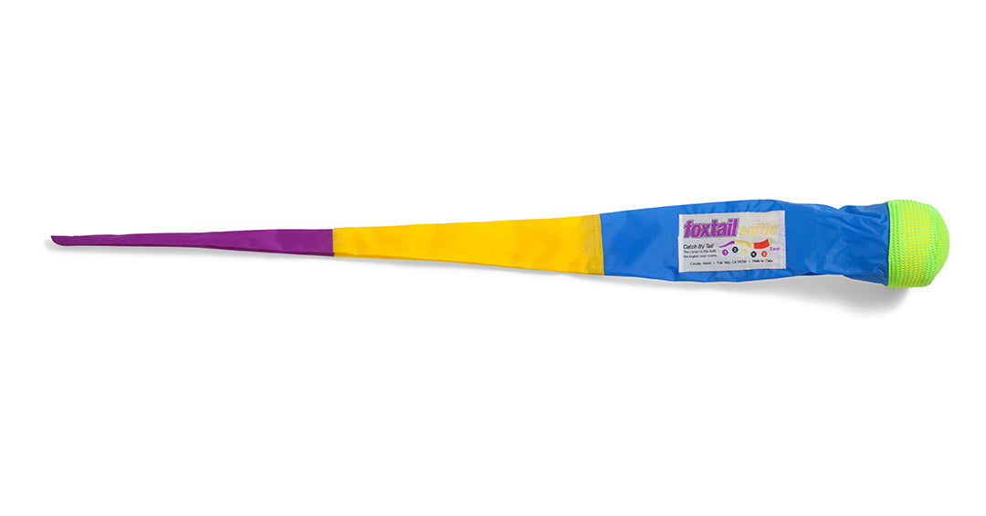 The Foxtail Softie is a colorful toy with a green ball and a long, segmented fabric tail in blue, yellow, and purple—“foxtail” on its blue section. Perfect for safe throwing, catching, and improving hand-eye coordination.
